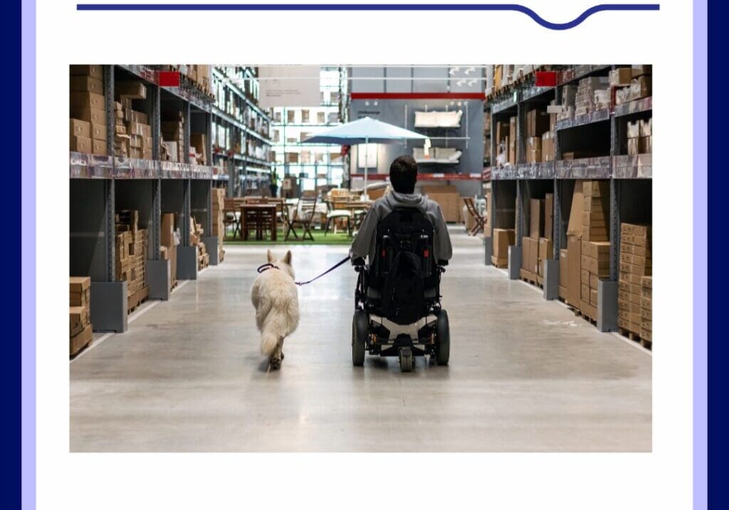 a man using a wheelchair rolling down a store isle with his service dog walking next to him